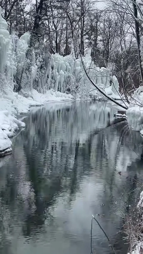 Crystal Clear Stream Flowing Through Snow Covered Forest Video stock 327957344