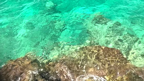 Crystal clear torquoise blue sea and rock Stock Footage 339880463