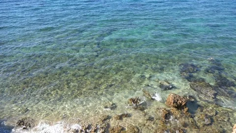 Crystal clear turquoise ocean water revealing a rocky seabed underneath. Stock Footage 337408537