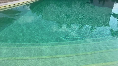 Crystal clear turquoise pool water sparkling under the summer sun, creating a Stock Footage 345035919