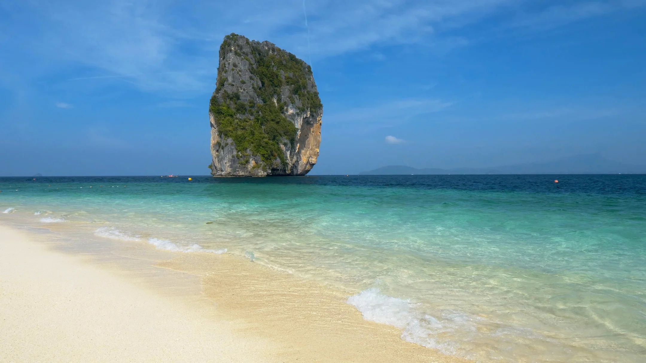 Turquoise colored crystal clear water at a rocky island