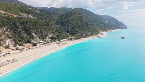 Crystal-clear turquoise waters, a long sandy beach and lush green mountains Stock Footage 336450790