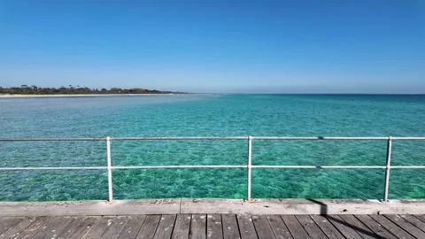 Crystal clear turquoise waters viewed from the wooden deck of Rosebud Pier Stock Footage 306630772