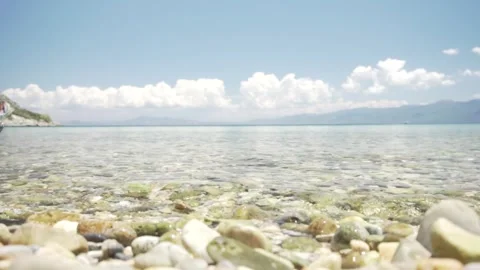 Crystal clear water gently lapping on a pebble beach Stock Footage 289663370