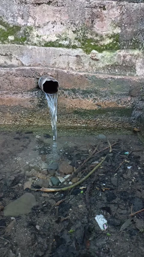 Crystal Clear Water Pouring from a Rustic Metal Pipe Stock Footage 333531061