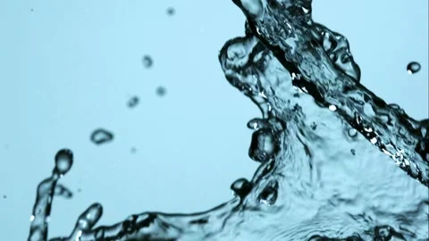 Crystal clear water splashes and collides in mid air against a blue background Stock Footage 326628943