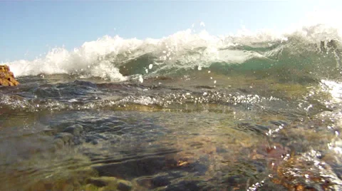 Crystal clear water splashes on to rocks in the Mediterranean Stock Footage