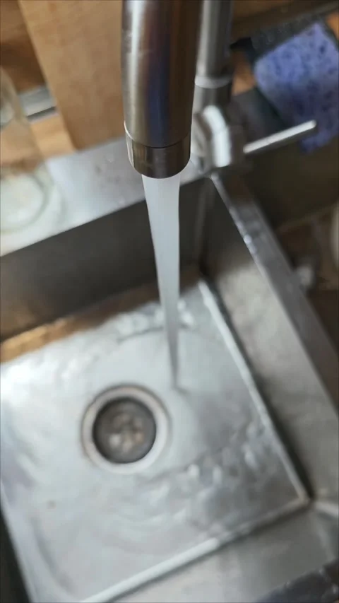 Crystal clear water streaming over sleek metal basin surface Stock-Footage 307494298