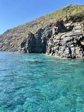 Crystal Clear Waters and Rocky Coastline of a Tropical Island Foto stock