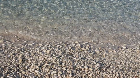 Crystal Clear Waters Gently Lapping a Sun-Drenched Pebble Beach. Perfect for Stock Footage 318089919