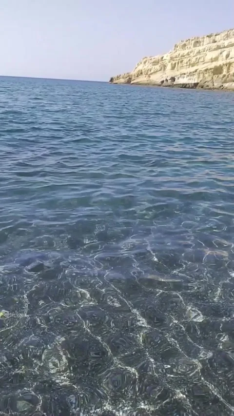 Crystal Clear Waters of Matala Beach with Iconic Caves Stock Footage 303437458