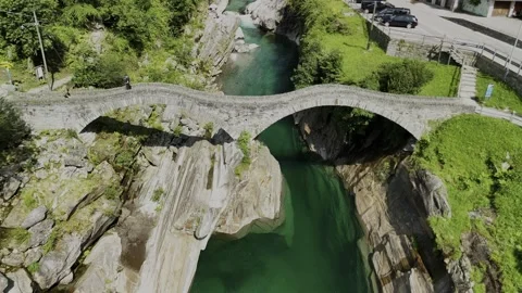 Crystal Clear Waters of Verzasca River with Stone Bridge Stock Footage 289660752