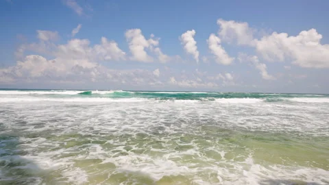 Crystal clear waves break gently on sandy beach, algae patterns on shore. Empty Stock Footage 268737766