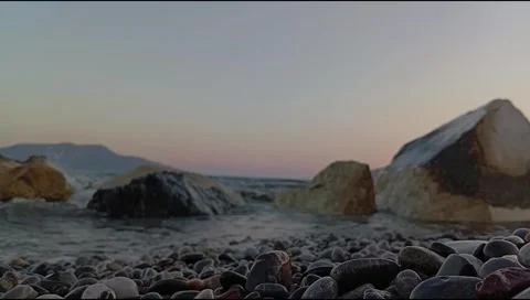Crystal-clear waves gently roll onto a rocky Mediterranean beach. Stock Footage 338203803