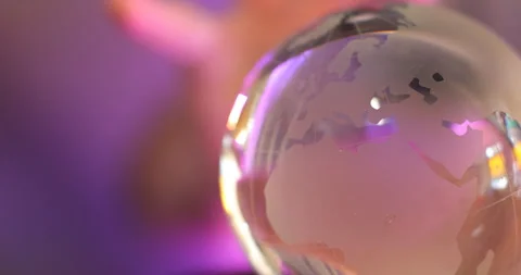 Crystal earth globe held by hand against vibrant purple light 스톡 동영상 347298411