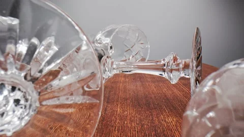 Crystal goblets are randomly placed on their sides on a wooden table. Stock Footage 211399290