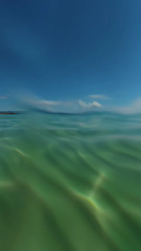 Crystal waters ripple beneath clear blue sky. Trani Ammouda, Vertical 스톡 동영상 340651599