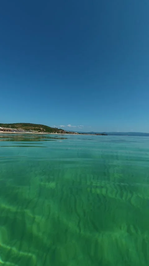 Crystal waters ripple under clear blue skies. Trani Ammouda, Greece. Vertical Vídeos de archivo 338358164