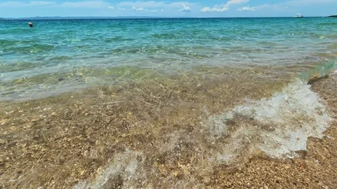 Crystal waves roll gently on sandy shore. Lagomandra, Greece Vídeos de archivo 339022689