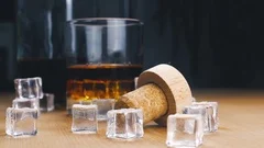 Ice cube falling into whisky glass – License Images – 11039807