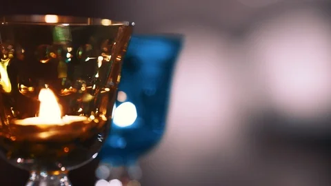 Crystal wine colored glasses moving in circle with candles inside. closeup Stock-Footage 99996609