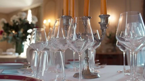 Crystal wine glasses on a formal dining table with lit candles 库存影片 332630097