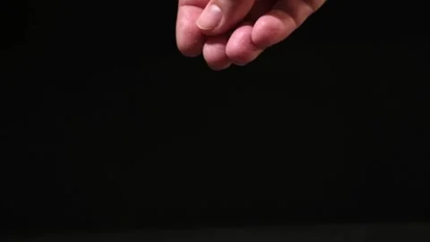 Crystals of table salt fall from the fingers of the hand on black background Stock Footage 239278254