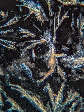 Crystals under polarized microscope showing subtle color fringe Foto stock