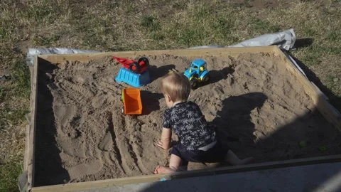 CSafe backyard playtime in the sandbox for young child Stock Footage 314310348