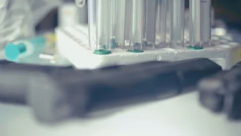 CSI expert table - gun and test tube close up Stock Footage 86413627