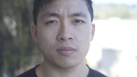 CU Asian Male looking at Camera Stock Footage 72840377