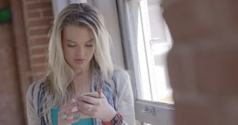 CU attractive blonde girl using phone and looking out window 4K Stock Footage 61899366