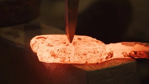CU of axe cutting red hot ingot by Master Sword smith. Japanese forge 스톡 동영상 125431750