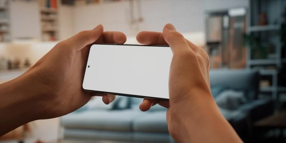 CU Caucasian man using his phone at home, daytime shot Stock Photos