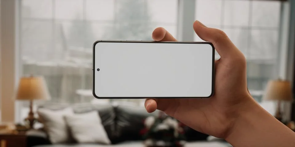 CU Caucasian man using his phone at home, daytime shot Foto stock