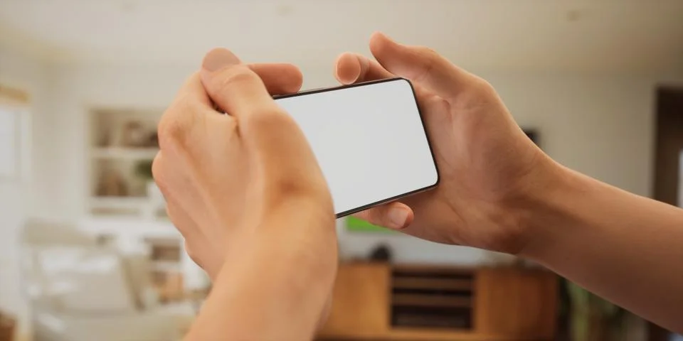 CU Caucasian man using his phone at home, daytime shot 写真素材