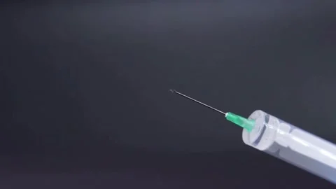 CU Clear liquid drips from needle of syringe Vaccine syringe slow motion macro Stock-Footage 336587426