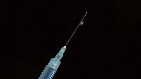 CU Clear liquid drips from needle of syringe Vaccine syringe slow motion macro Stock Footage 336587510