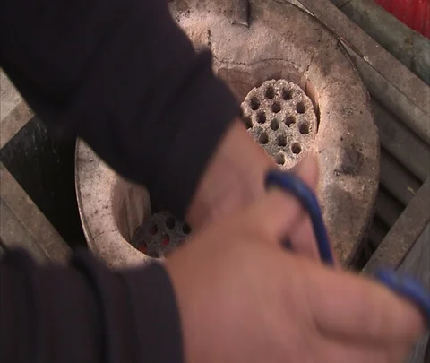 CU coal ash bricks being placed in coal fired stove Stock Footage 86745454