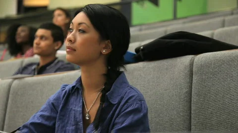 CU of female and students taking notes in lecture theatre Stock Footage 832430