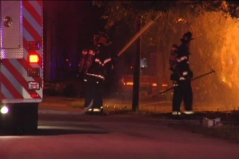 CU Firemen Hose Flames from Street 動画素材 852153