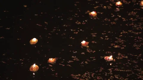 CU Illuminated offerings floating down river Ganges at night / Varanasi, India Stock Footage 69962546