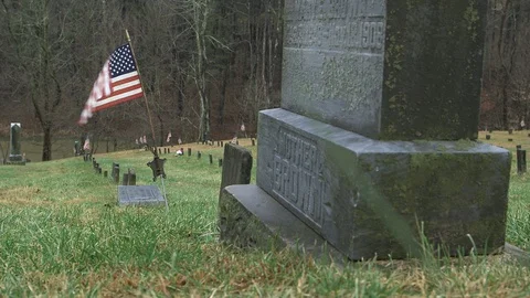 CU of Large Grave Stone and Small American Flag in Cemetery HD Video Stock Footage 92368489