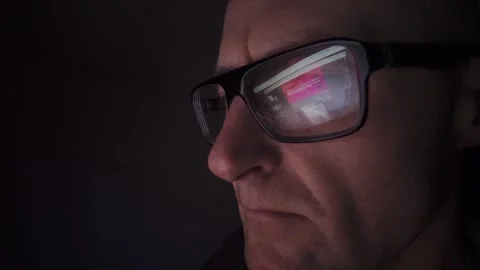 CU Man on computer in dark room, screen reflection in glasses. Hull.UK. 1.1.2026 Stock Footage 327158733