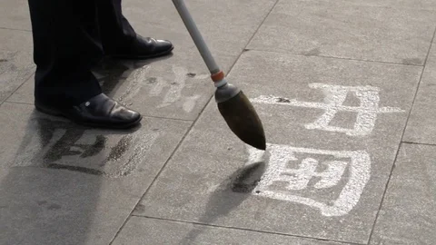 CU Man writing Chinese calligraphy on pavement with water / Beijing, China Stock Footage 69959159