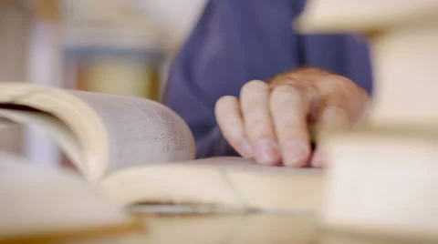 CU of a man's hand scanning a book for information while he reads Video stock 65909001