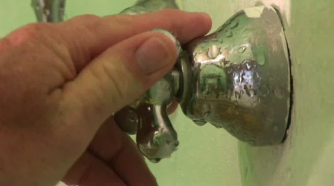 CU of man's hand turning shower handle on and off Stock Footage 574510