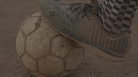 CU of old football boots resting on old ball and then kick - No Grade Prores422 Stock Footage