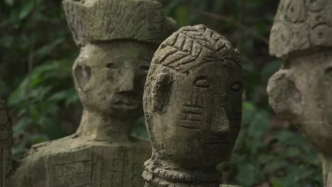 CU pan across faces of deity sculptures in Sacred Grove. Stock Footage 86761316