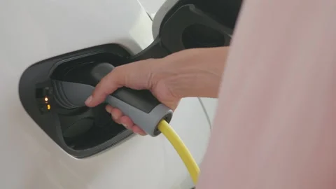 CU plugging charger into pollution-free electric car Stock Footage 132737045